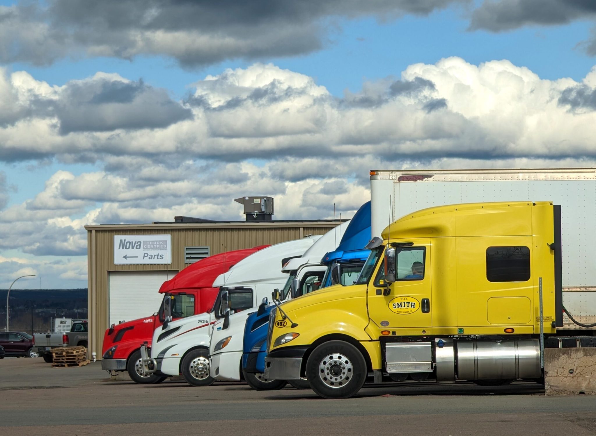 Parked semi-trucks of various colors outside a Nova Parts warehouse in Truro, NS.
